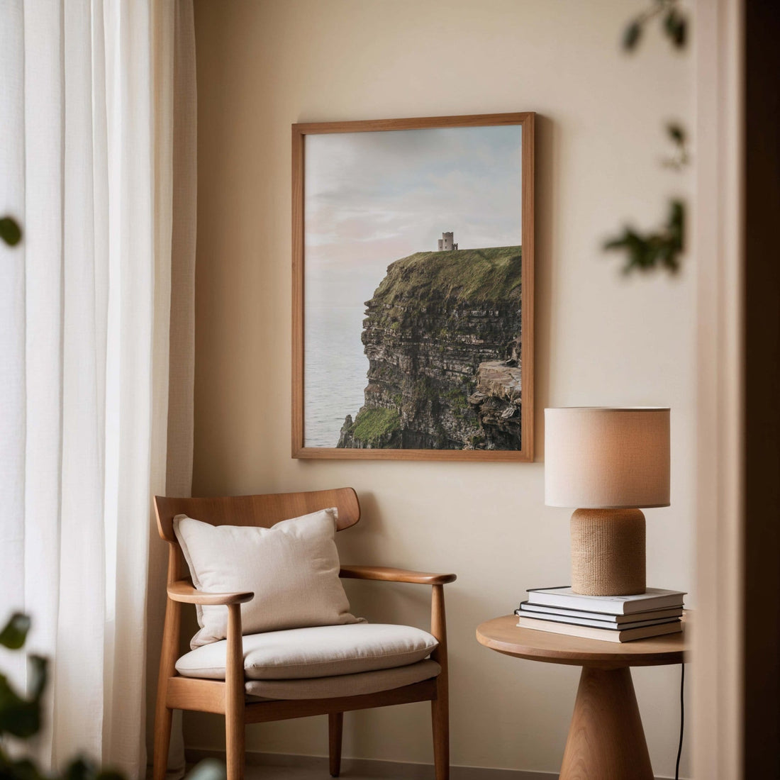Framed Cliffs of Moher landscape print on a wooden chair beside a side table and lamp in a modern living room