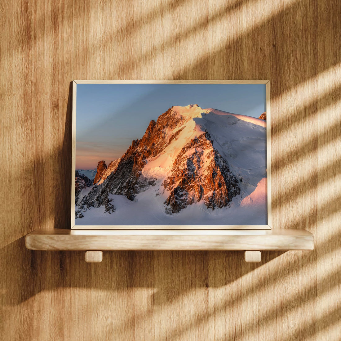 Mont Blanc du Tacul print in a frame hung on a wooden wall, lit by natural sunlight