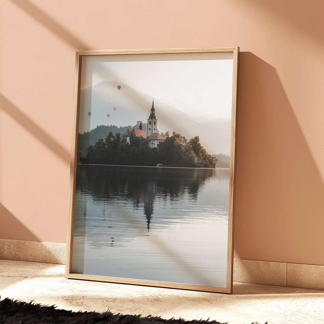 Lake Bled print styled on bed with pillows in warm morning light