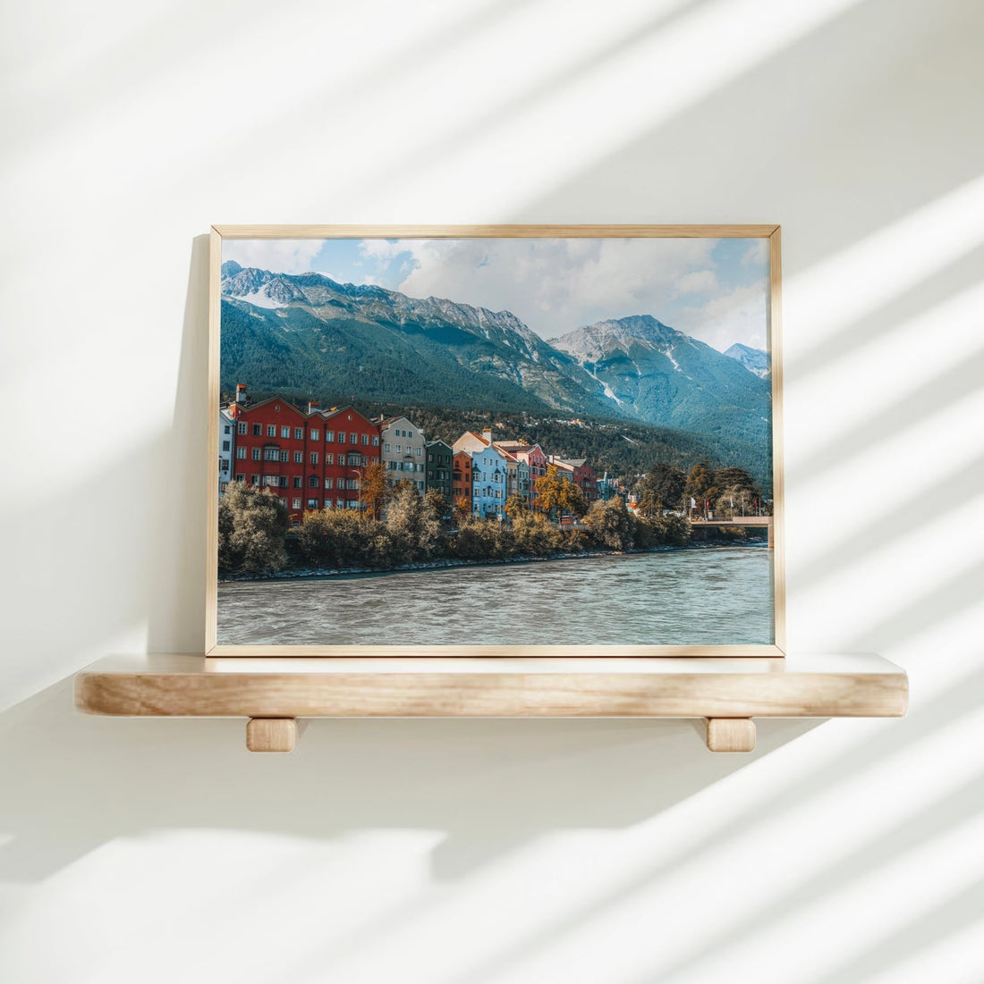 Framed Innsbruck photo print on white bedsheets with soft natural morning light.