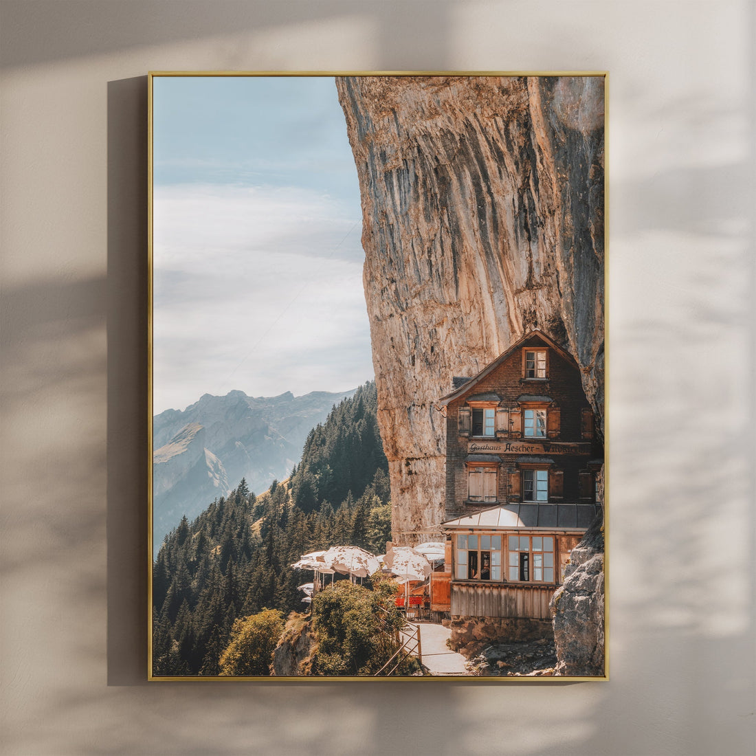 A breathtaking view of Aescher Guesthouse, a mountain lodge built into a cliff in Switzerland.