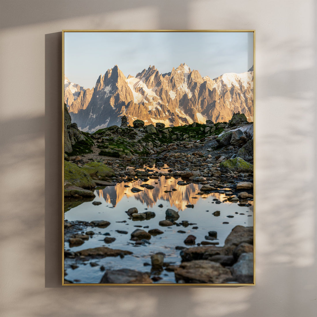 Breathtaking reflection of Aiguille de Chamonix in an alpine pool, captured in golden evening light.