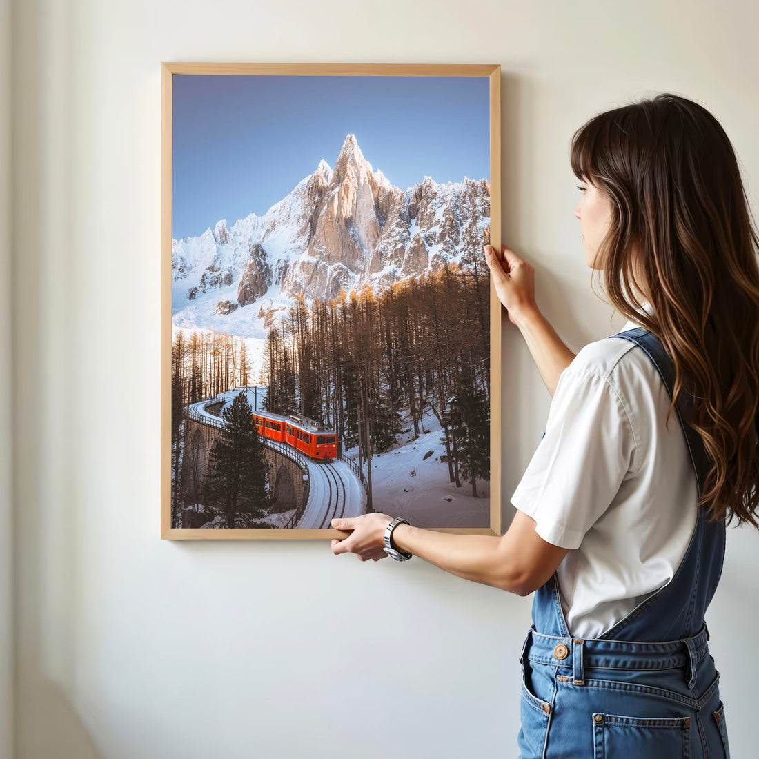Captivating wall art of the Montenvers Train curving along the snowy tracks with Aiguille du Dru’s dramatic peaks behind.