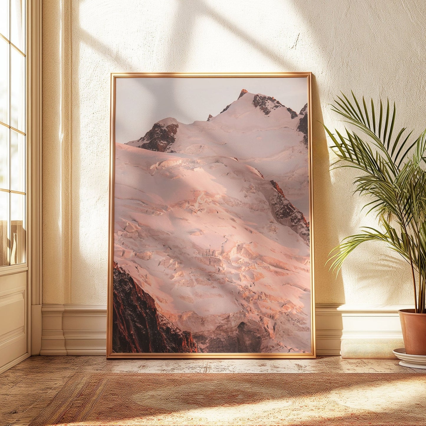Close-up view of the Aiguille du Midi at sunset with pink-hued snow and rugged peaks.
