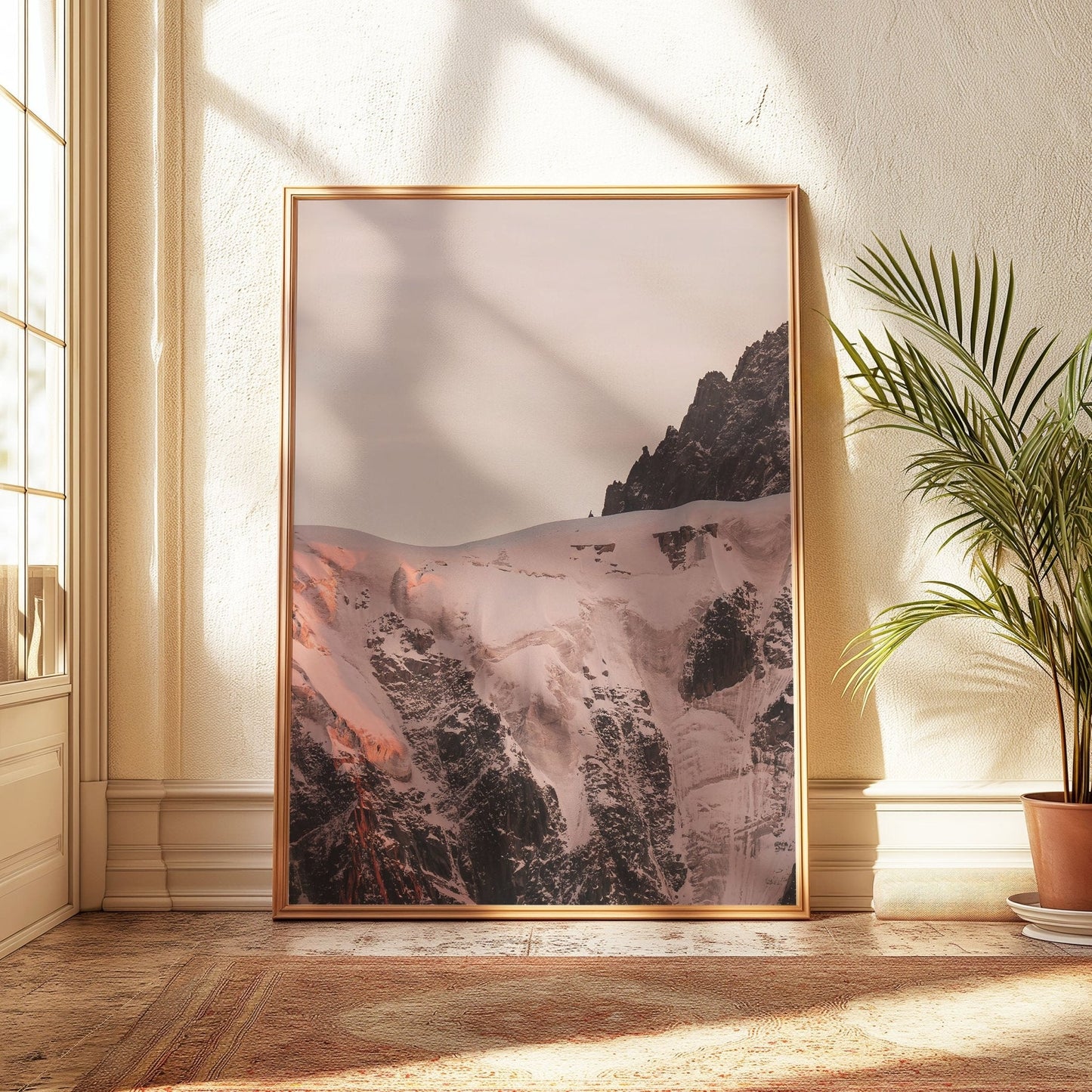 Side view of the Aiguille du Midi surrounded by glowing snow during sunset.