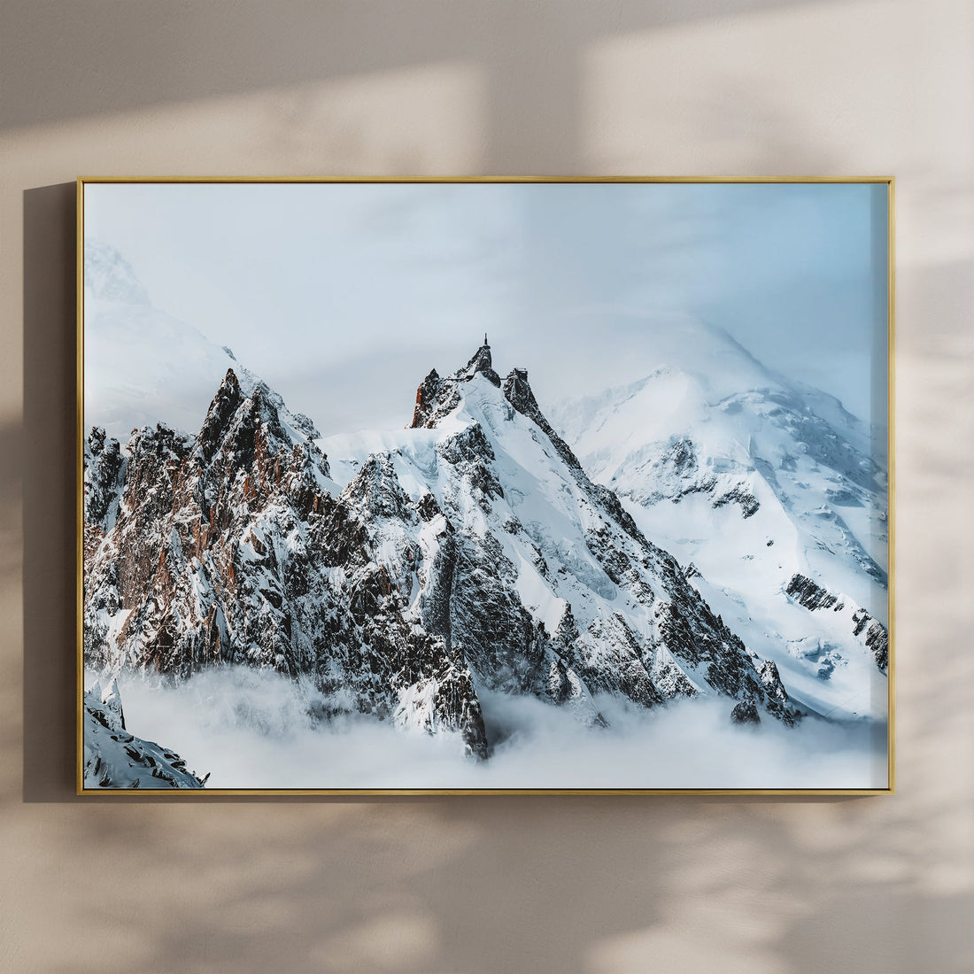 Snow-covered Aiguille du Midi with blue sky and golden frame