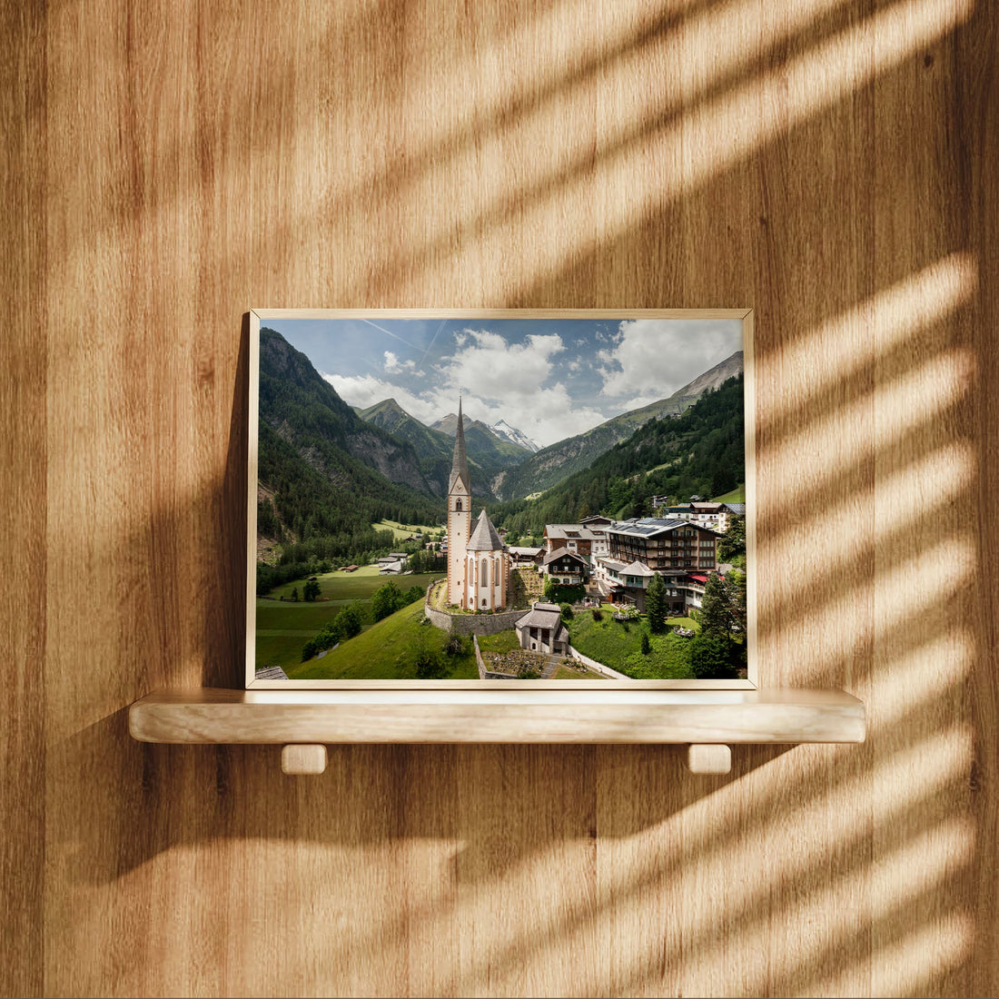 Heiligenblut photography print displayed on wood shelf with sunlight shadows