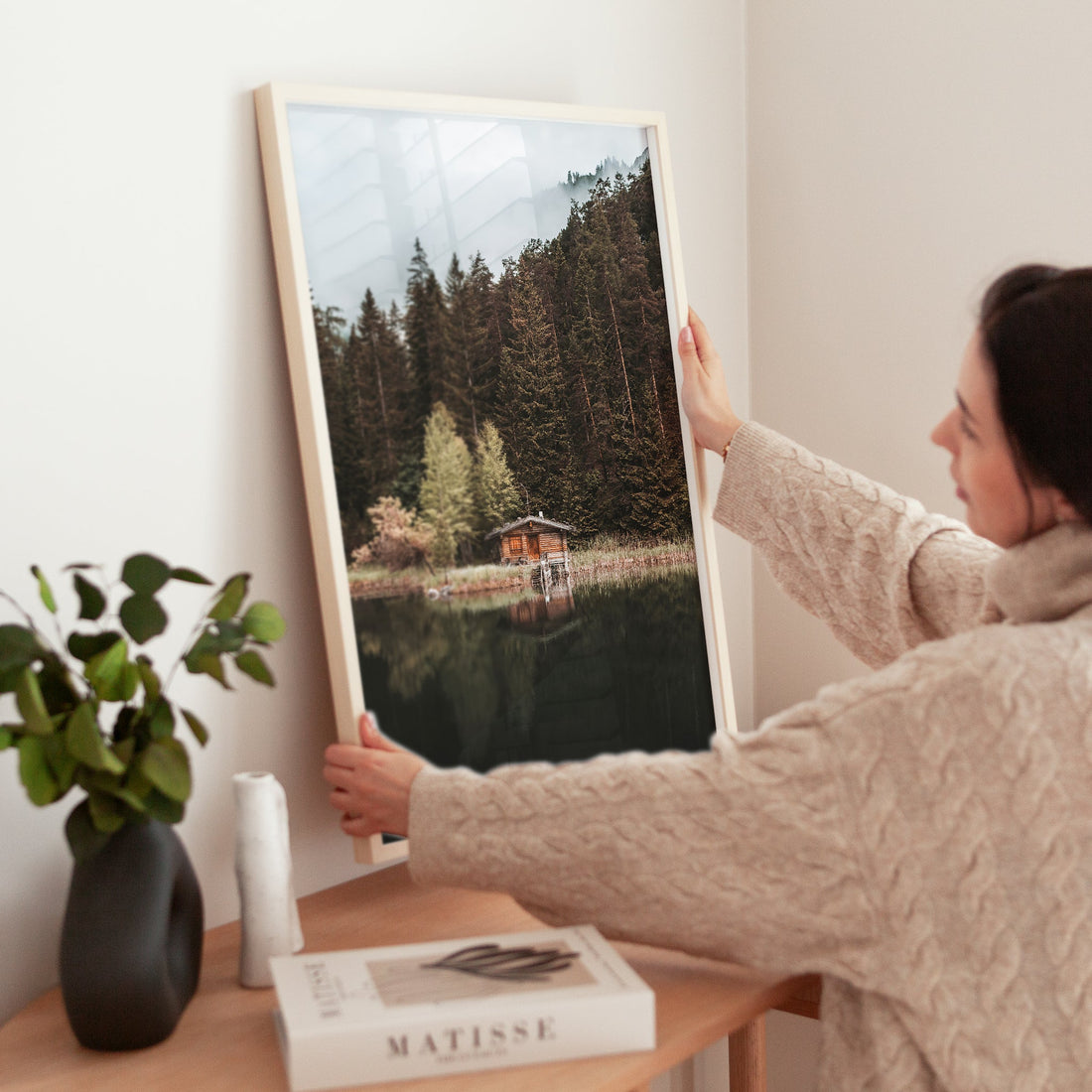 Woman styling Mittersee alpine lake art print in cosy home interior
