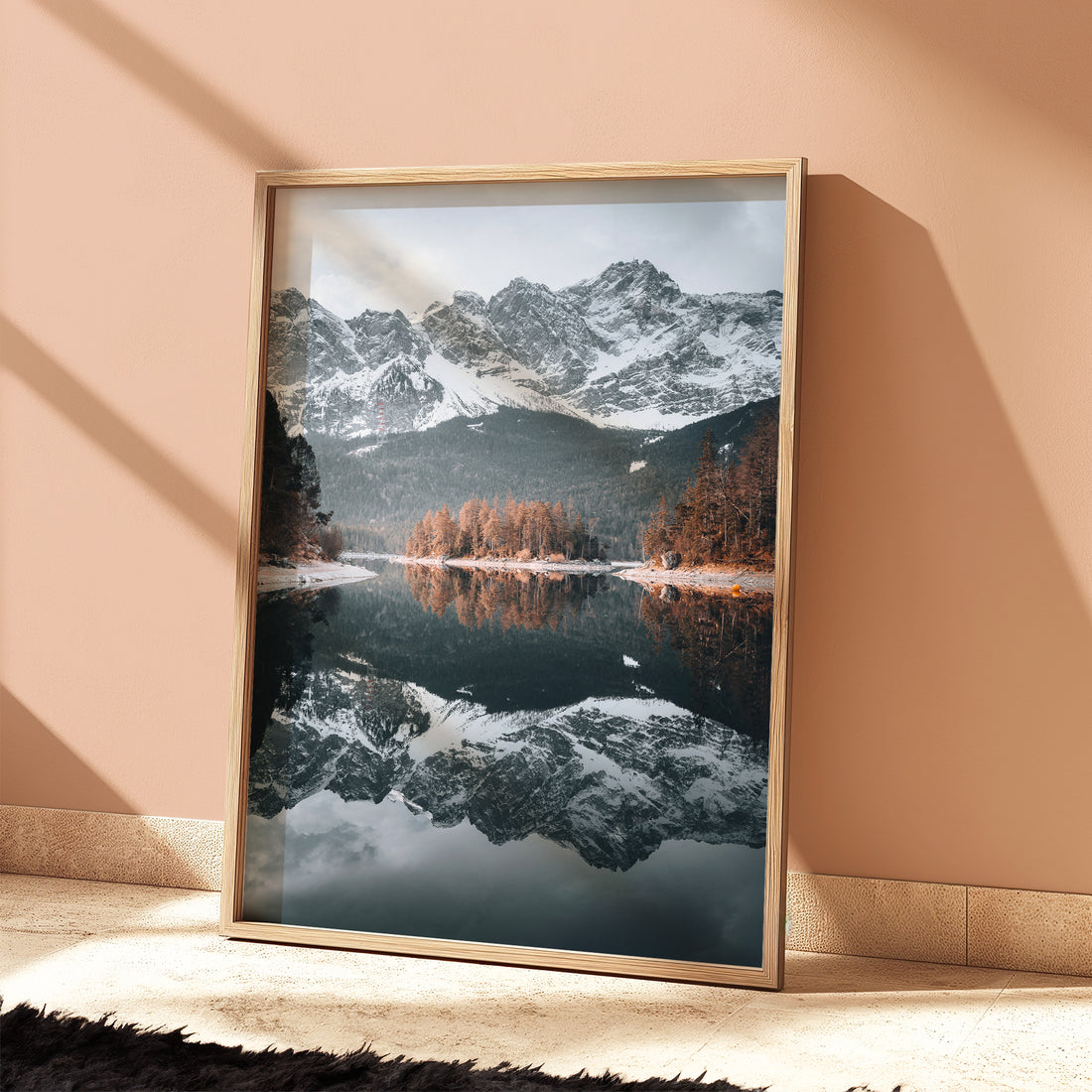 Scenic alpine wall art of Eibsee and snowy mountains styled in a sunlit room