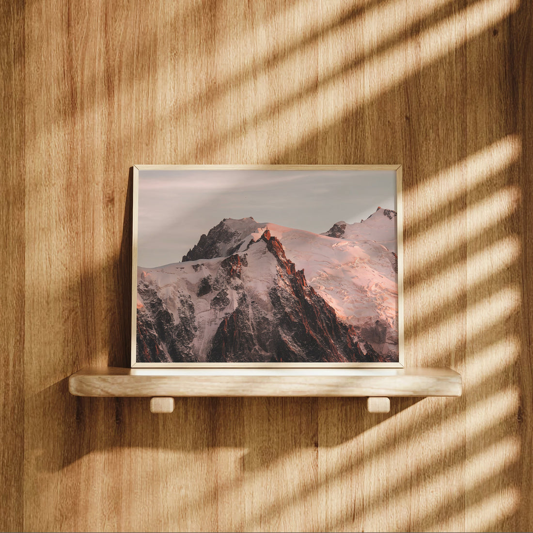 Warm-toned sunset photo of Aiguille du Midi glowing above the French Alps in Chamonix.