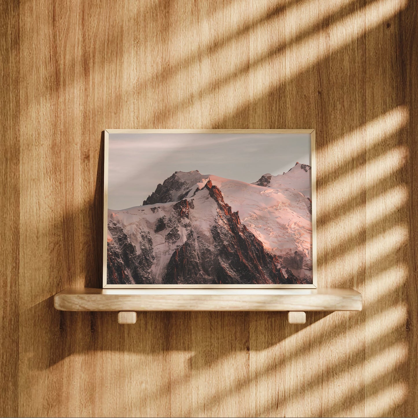 Warm-toned sunset photo of Aiguille du Midi glowing above the French Alps in Chamonix.