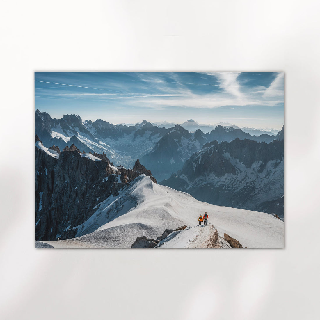 Fine art photography print of an alpine ridge in Chamonix with two skiers hiking across snow-covered terrain.