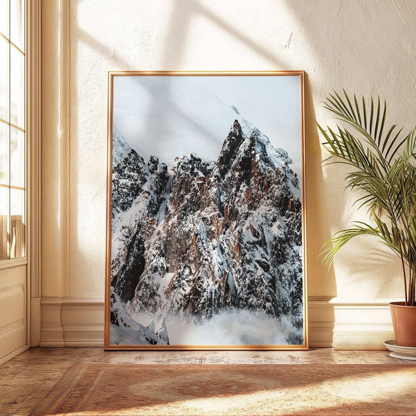 Snow-covered Alpine peaks surrounded by misty clouds on a sunny day.
