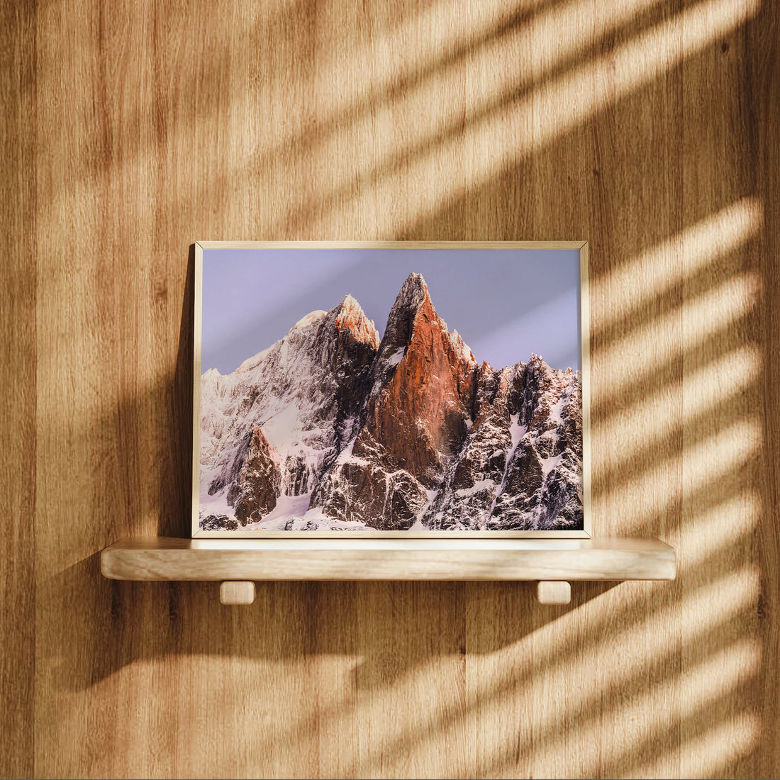 Photography art print capturing Les Drus glowing at dawn above snowy ridges in Chamonix’s high alpine valley.