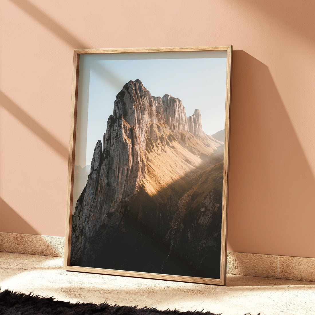 Sunlit Saxer Lücke mountain print leaning against a pastel peach wall.