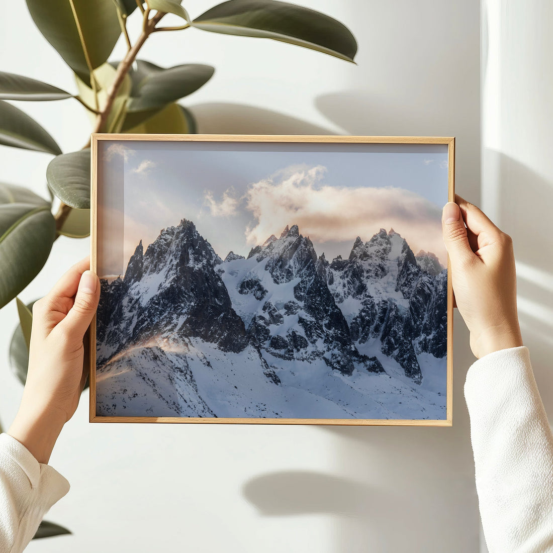 Hands holding framed print of Chamonix summits lit by sunset glow