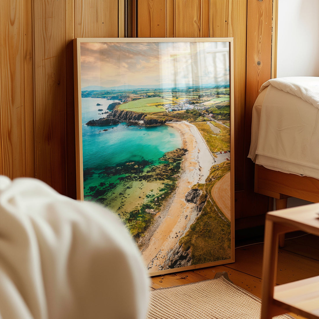 Annestown Beach coastal wall art leaning beside a bed in wooden room