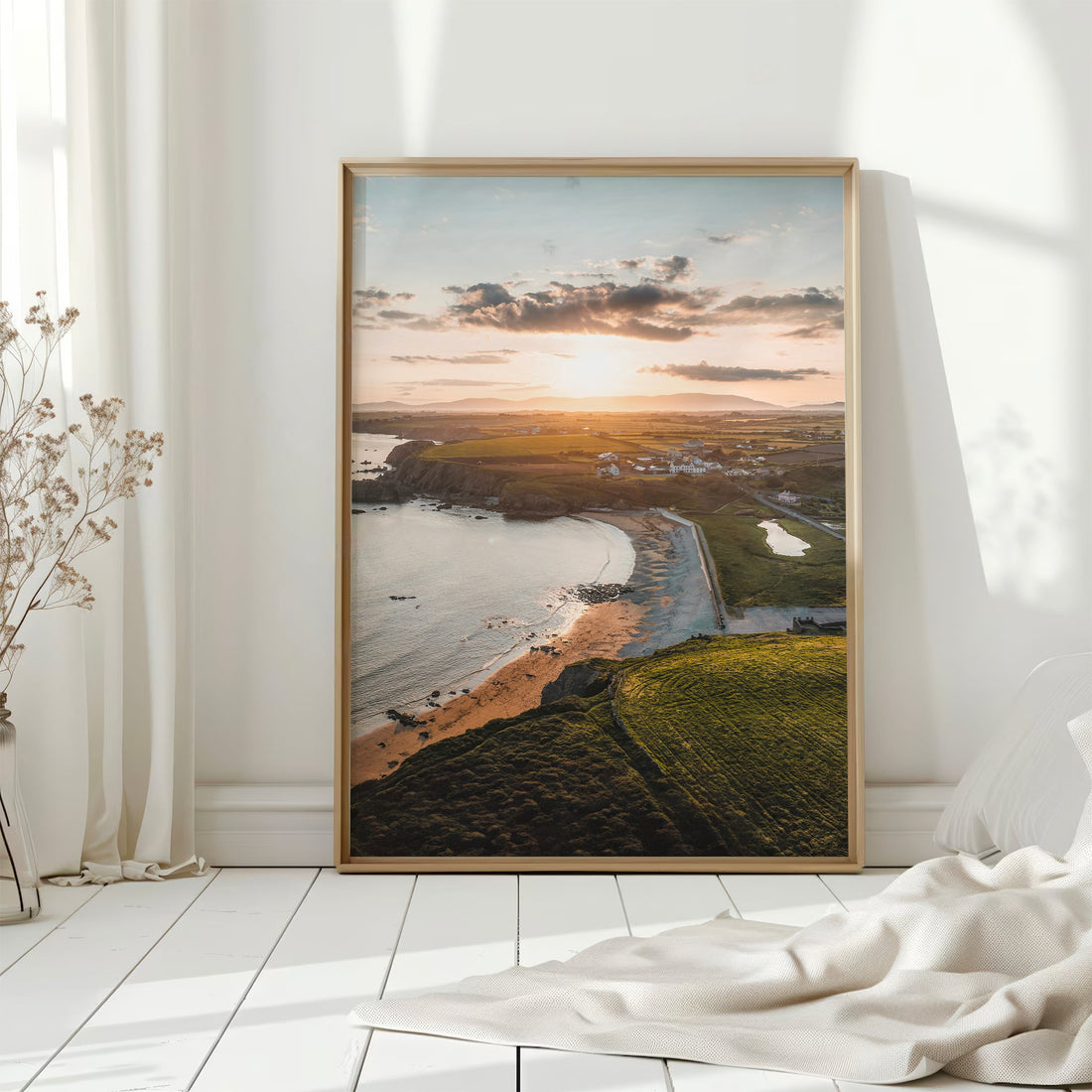 Aerial photo print of Annestown Beach on white wood floor with bright light and curtains