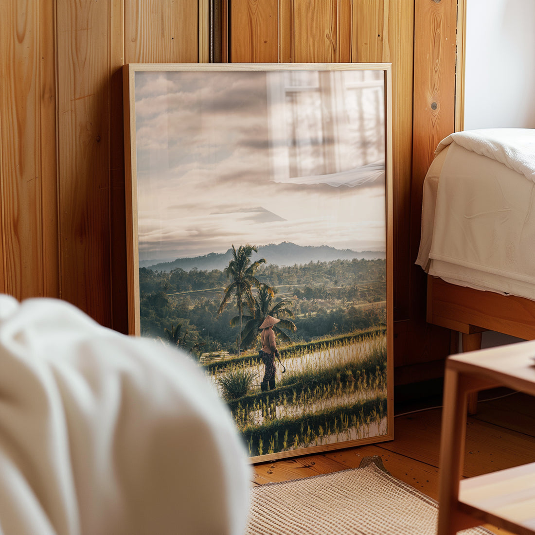 Bali rice fields wall print leaning against wooden wall in cozy bedroom interior