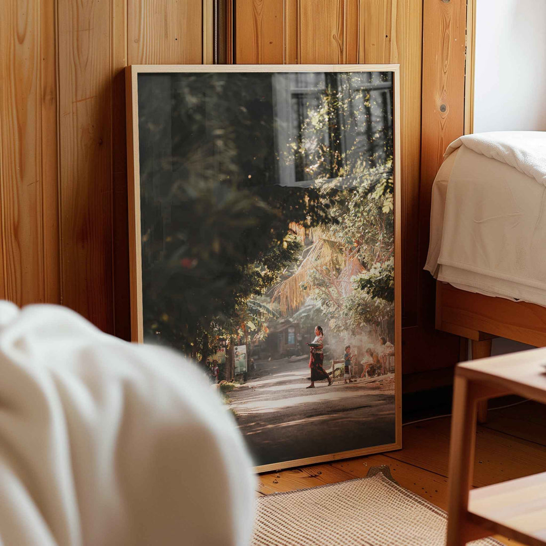 Bali village street photography framed print leaning against wooden wall in cosy bedroom interior