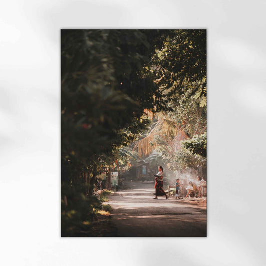 Bali village street photography print with Balinese woman in traditional dress and golden jungle light unframed on white background