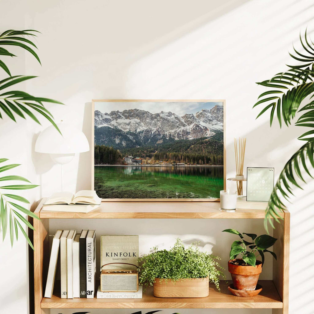 Framed Eibsee poster in a bright room with books, plants, and warm decor