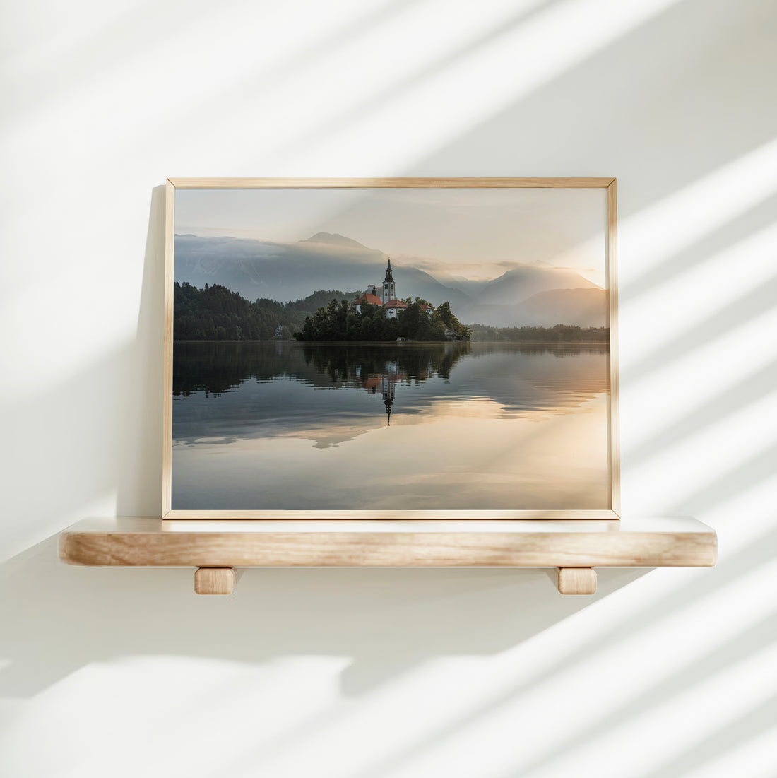 Reflective lake and Bled Island in soft golden sunrise