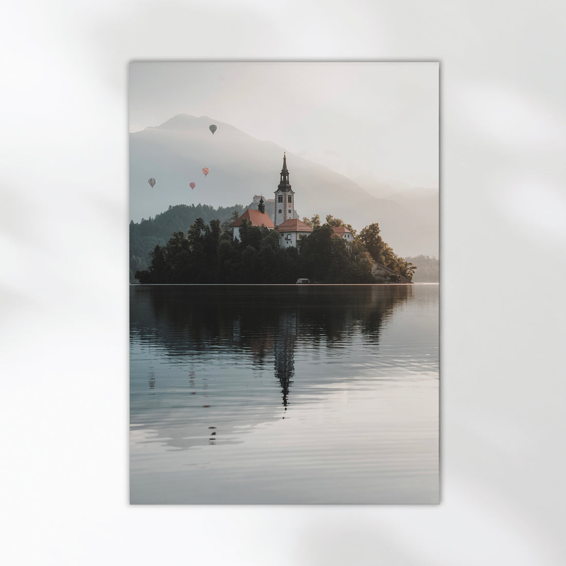 Peaceful view of Lake Bled island and misty Alps in soft morning light