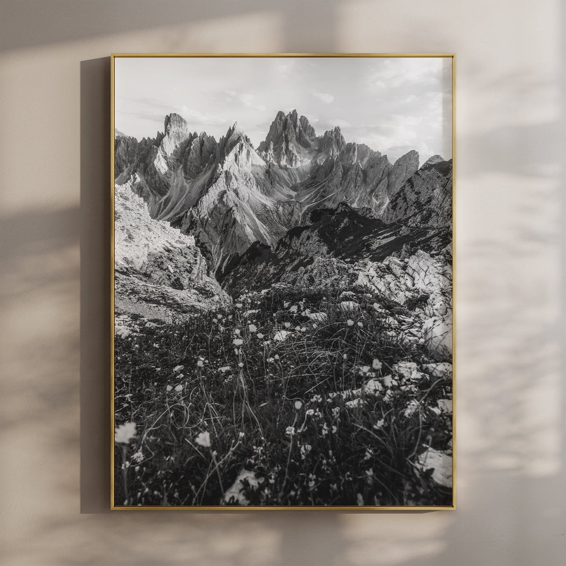 Black and white print of the Cadini di Misurina peaks hanging on a neutral wall in golden light.