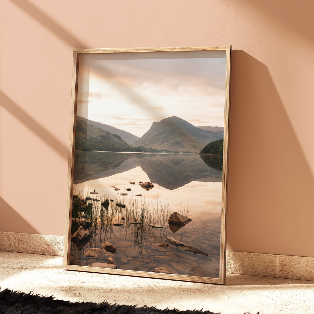 Tranquil Buttermere landscape with soft colours and glass-like water reflection.