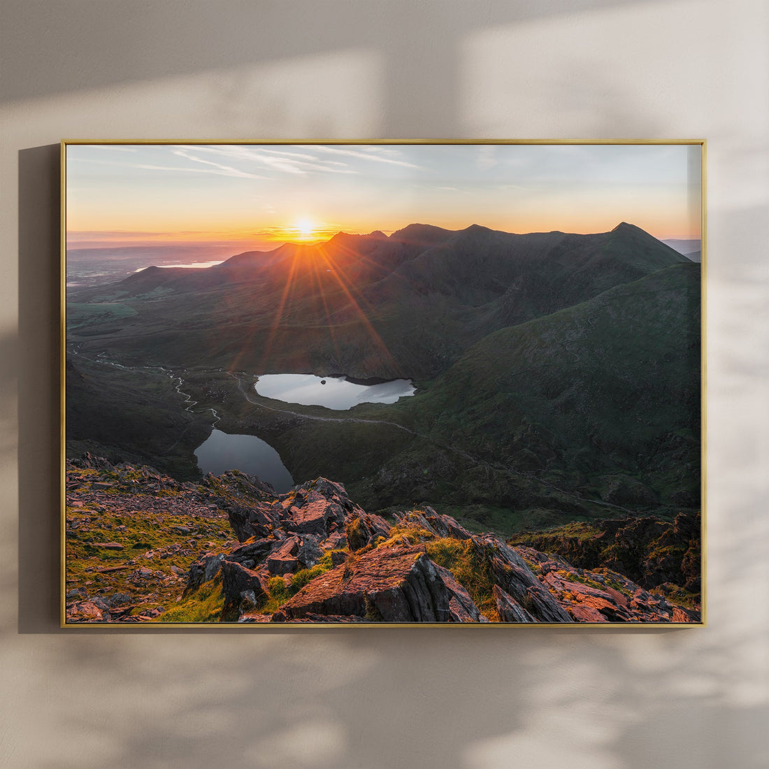 Sunrise view over Carrauntoohil and alpine lakes in golden light.