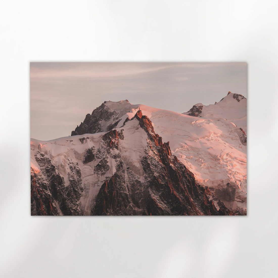 Sunset wall art print of Aiguille du Midi peak in Chamonix with glowing snow and pink alpine light.