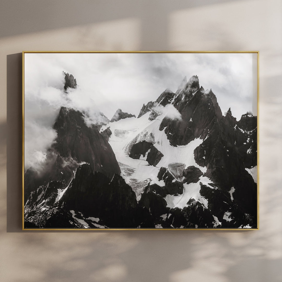 Dramatic black and white print of the Needles of Chamonix with jagged alpine peaks and swirling mountain clouds.