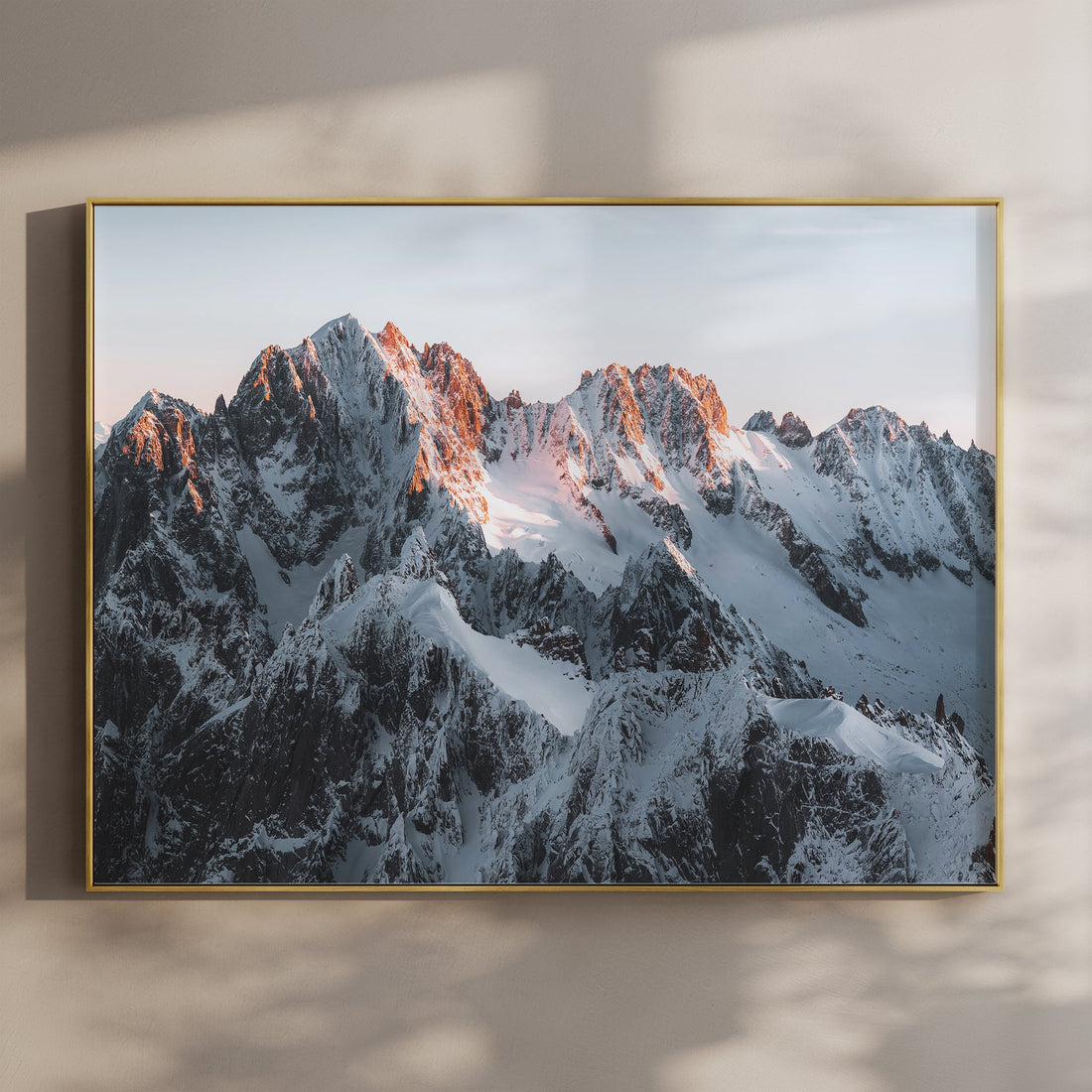 Fine art wall print of Chamonix’s jagged mountain peaks bathed in warm sunrise light over the French Alps.