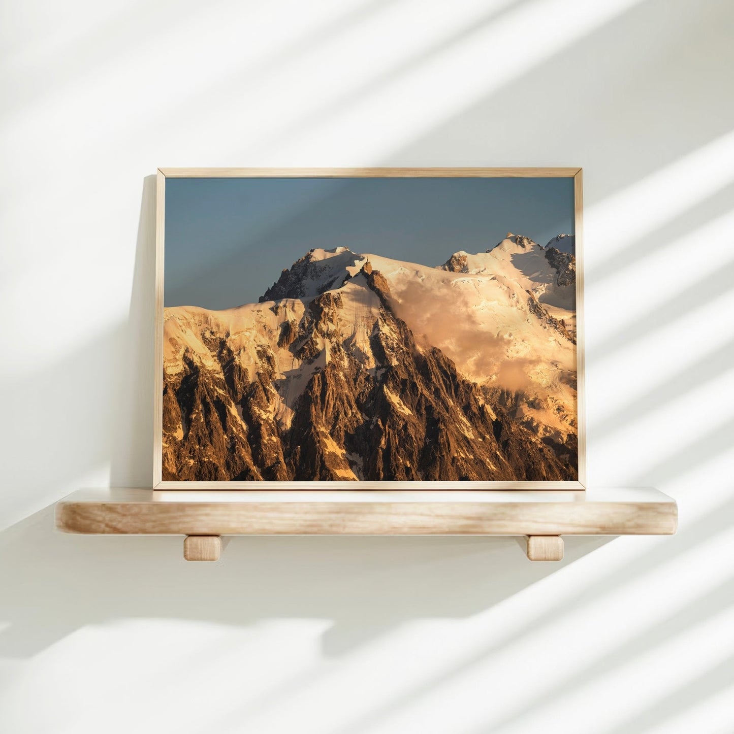 Chamonix summit wall art showcasing Aiguille du Midi with early morning clouds and sun-drenched snow fields.