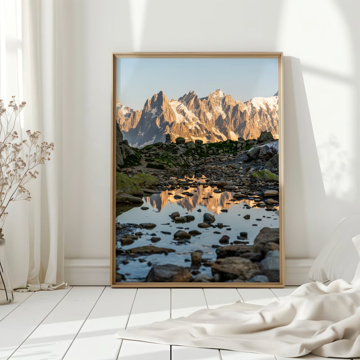 Sunset over the Chamonix mountain range, casting a golden glow on the jagged peaks and their mirrored reflection.