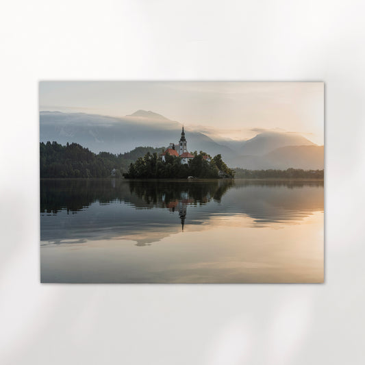 Church on Lake Bled surrounded by misty morning mountains