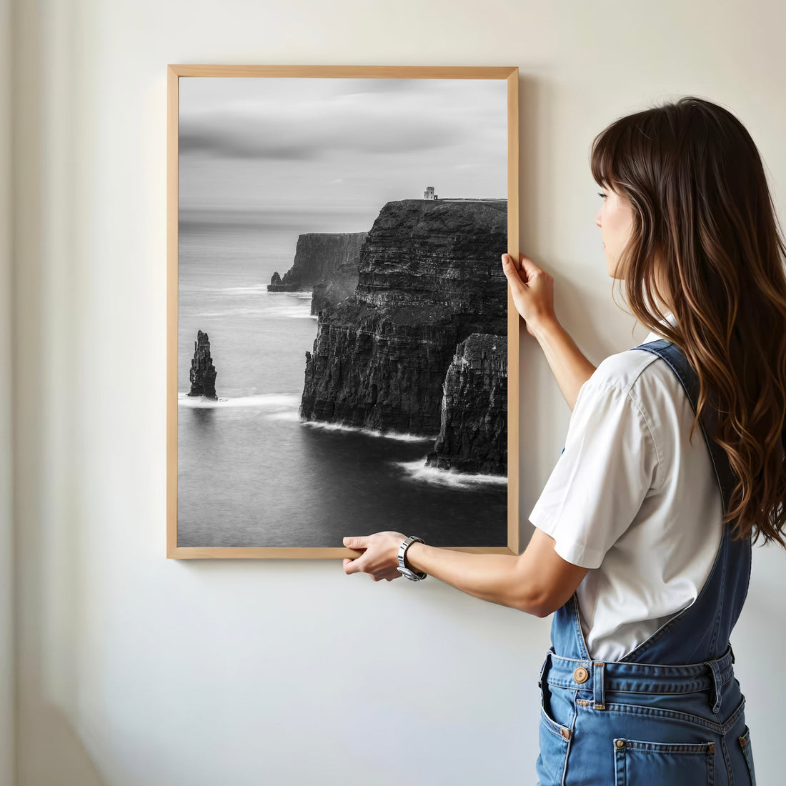 Woman hanging Cliffs of Moher black and white framed print on white wall