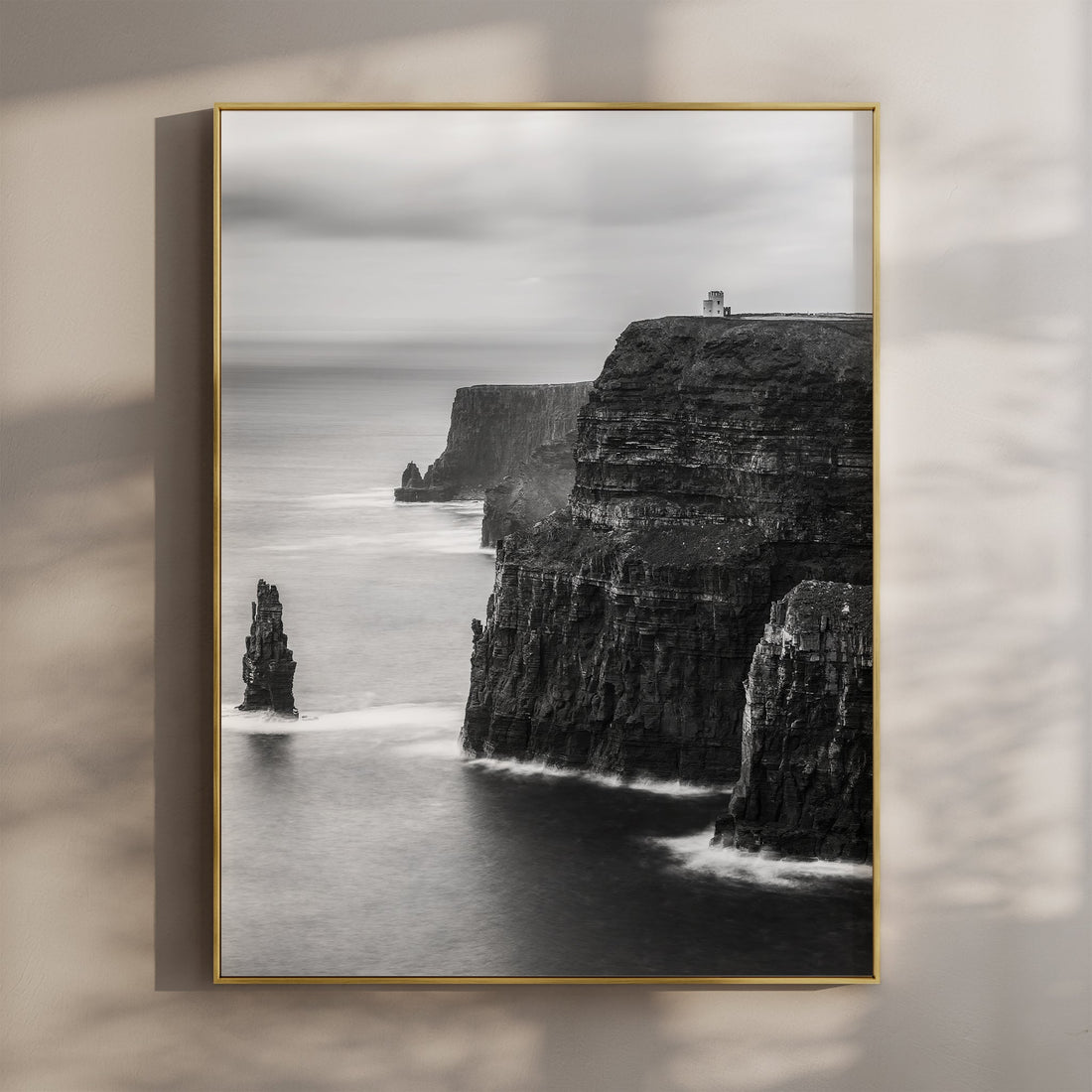 Black and white print of the Cliffs of Moher in gold frame with natural shadows