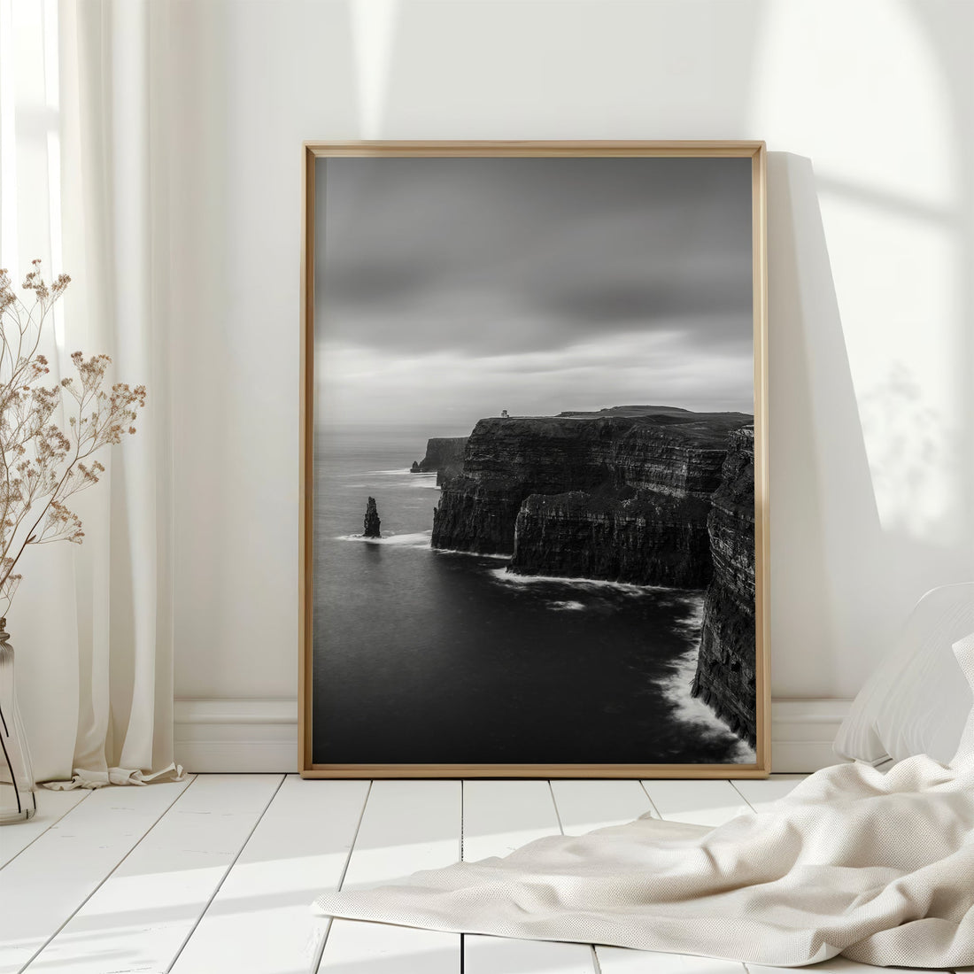 Framed Cliffs of Moher print displayed on floor in white Scandinavian room