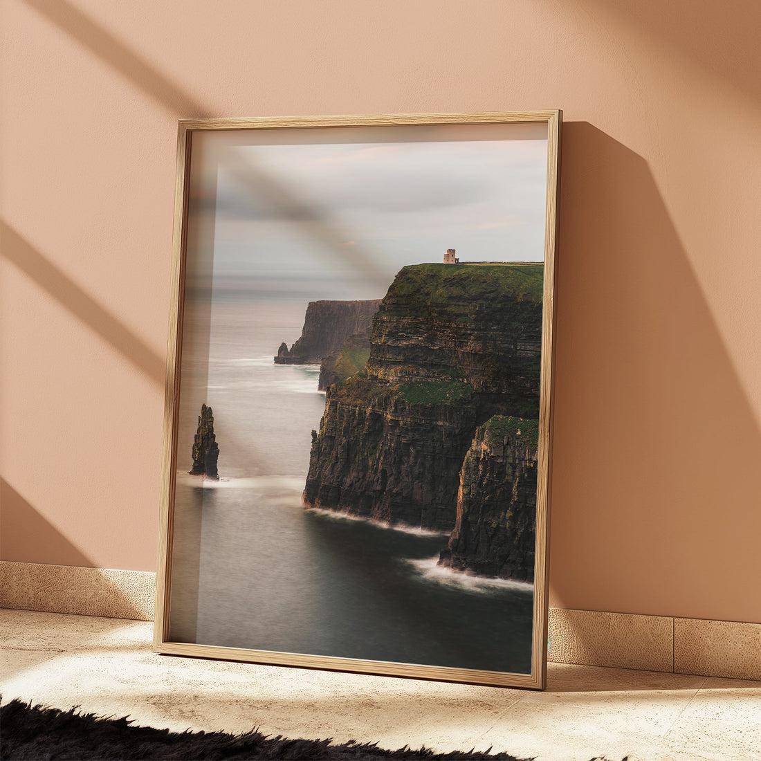 Coastal cliffs of Ireland framed artwork catching warm light in a styled room