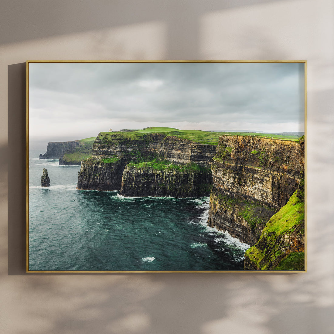 Framed print of the Cliffs of Moher on a soft-toned wall with natural light shadows