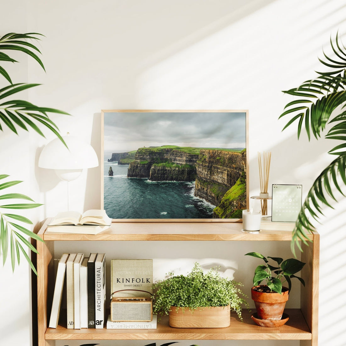 Framed Cliffs of Moher print styled in a home interior with books and greenery