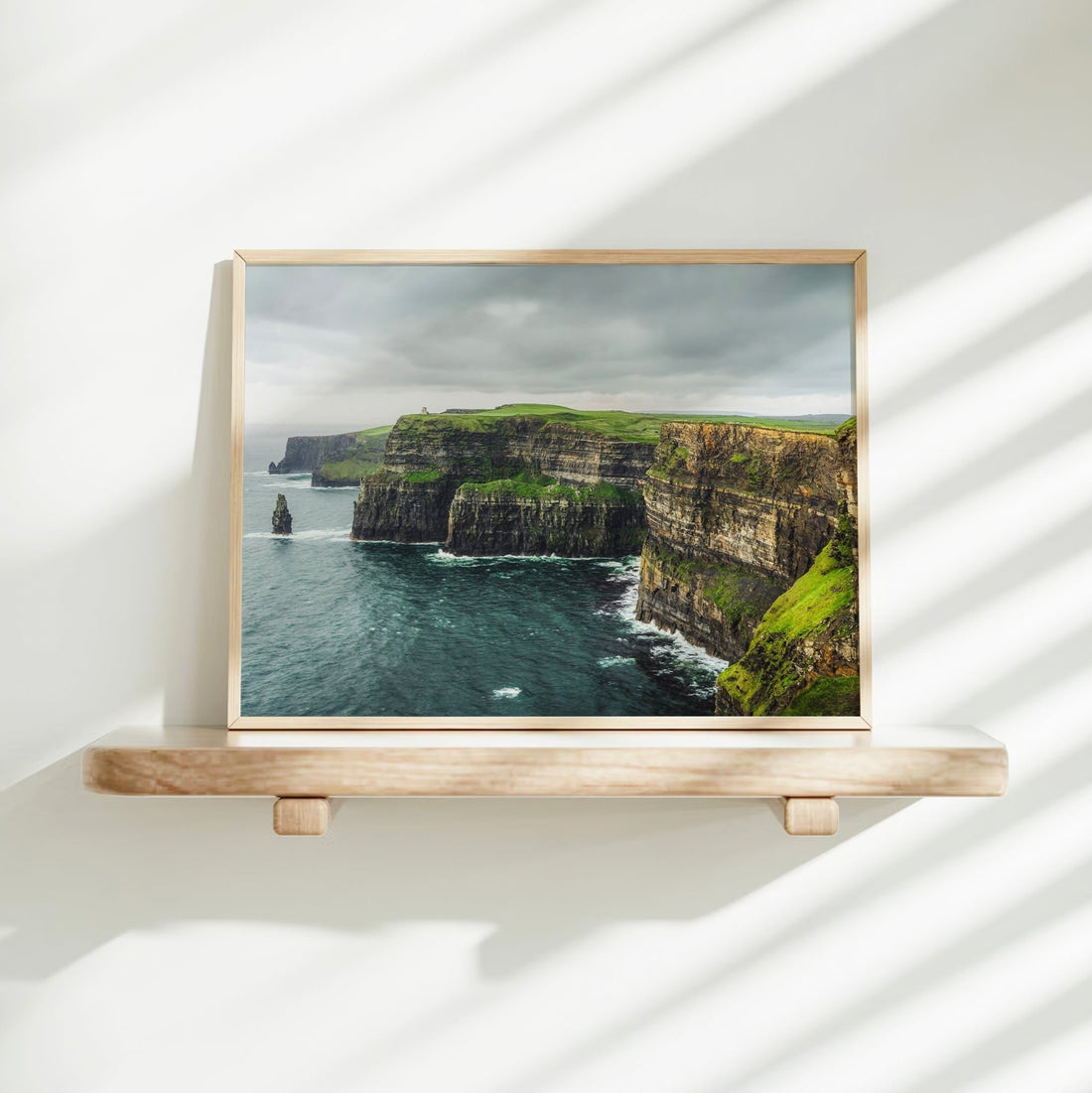 Cliffs of Moher art print on a bright shelf with simple modern decor and sunlight