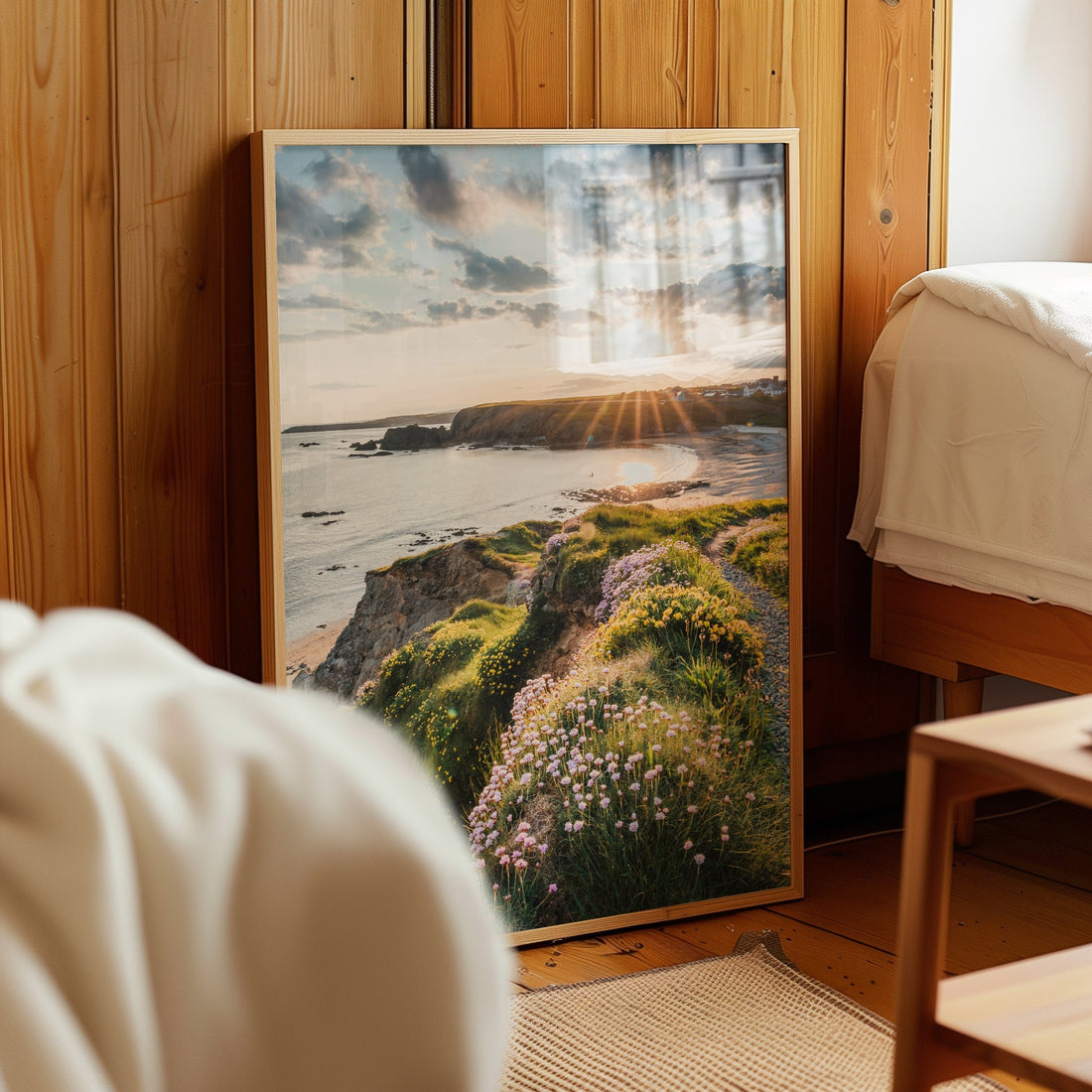 Framed landscape photography print of Annestown Beach leaning on a wooden wall in a cosy room.