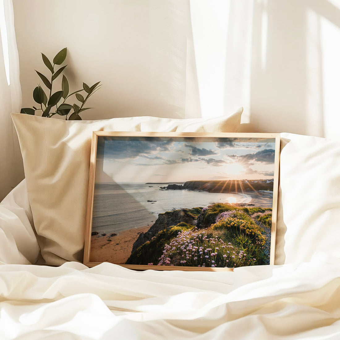 Annestown Beach print on a bed with golden sunlight and soft shadows