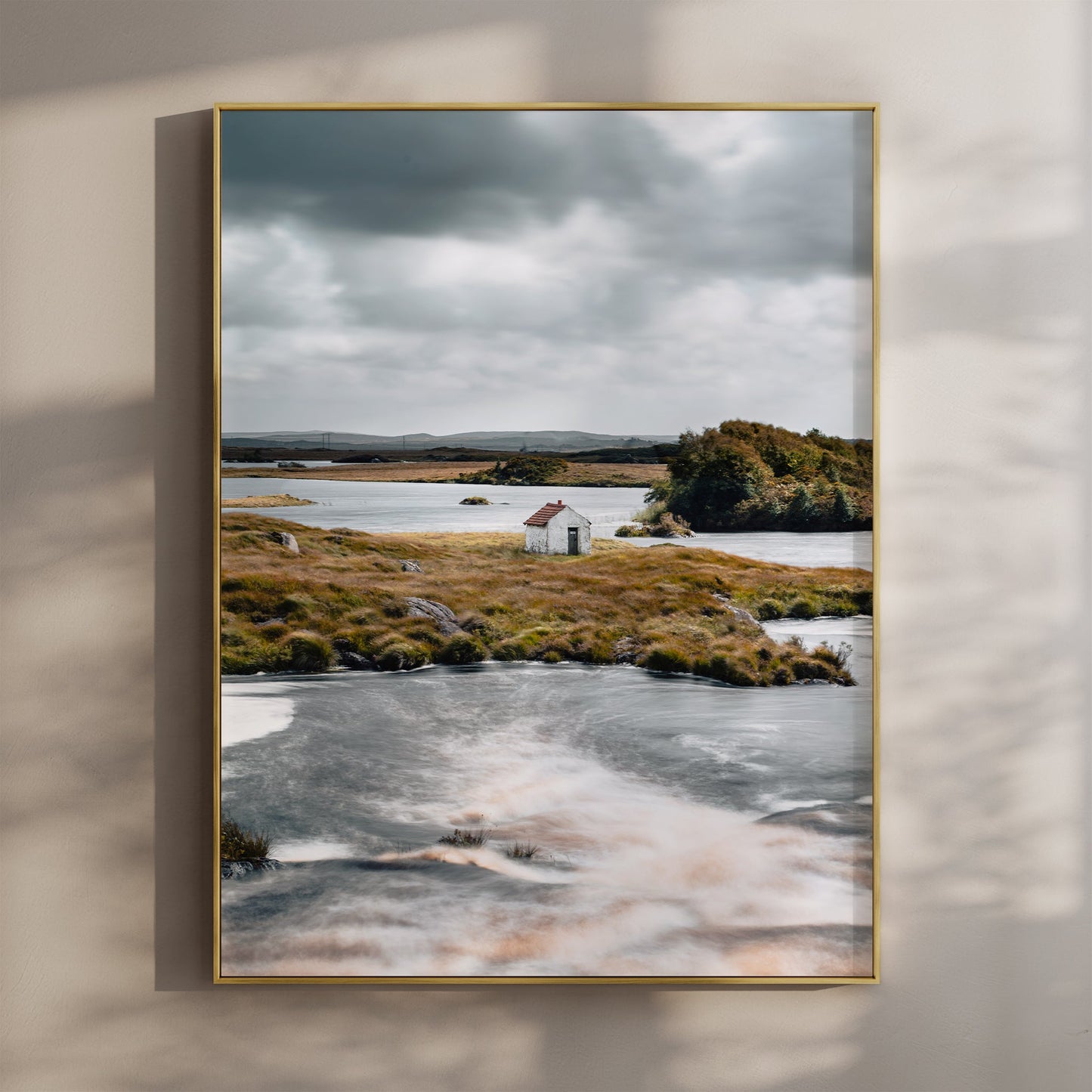 Fine art print of a small white hut on a lake in Connemara, Ireland with dramatic clouds