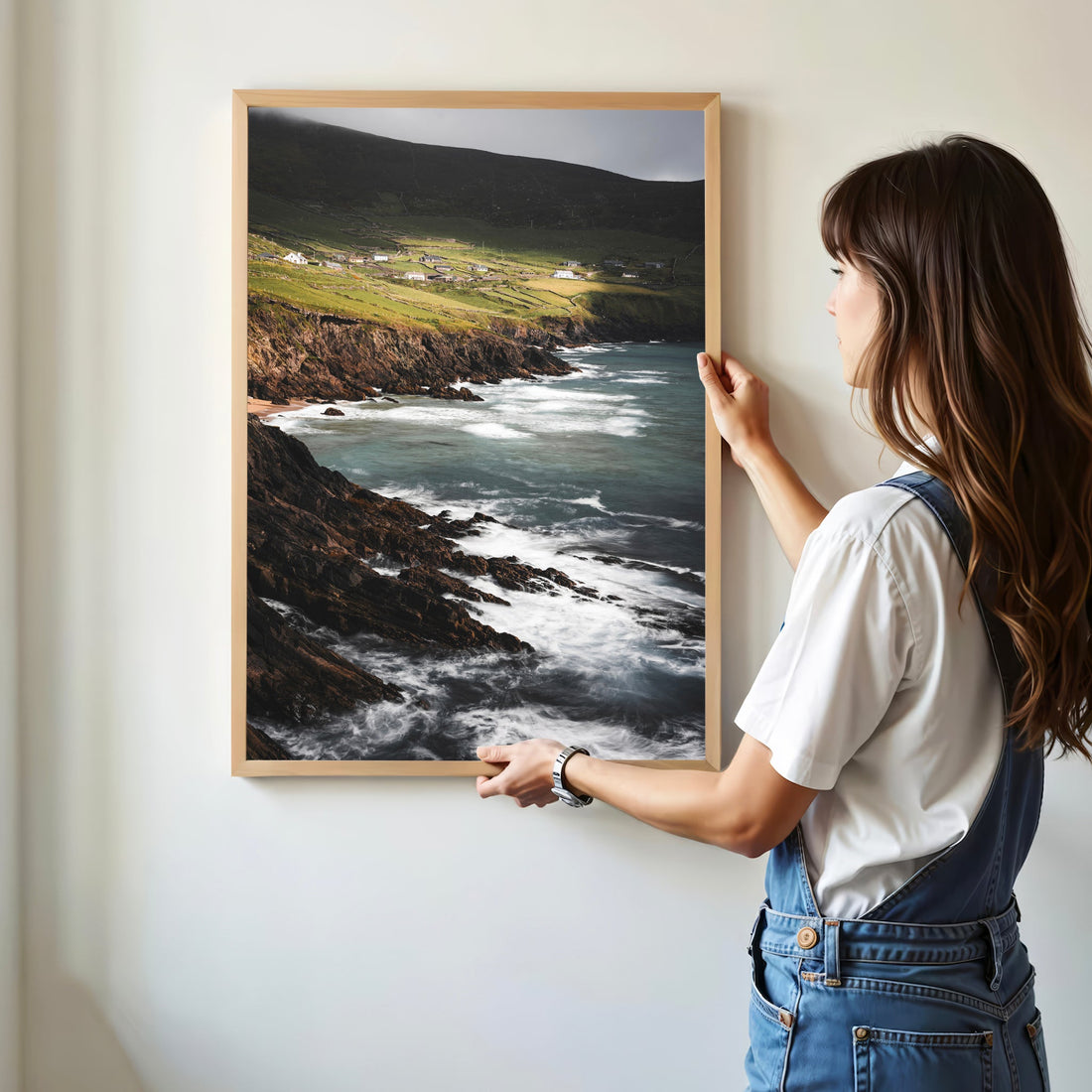Woman holding framed print of Coumeenoole Beach on the Slea Head Drive, Ireland.