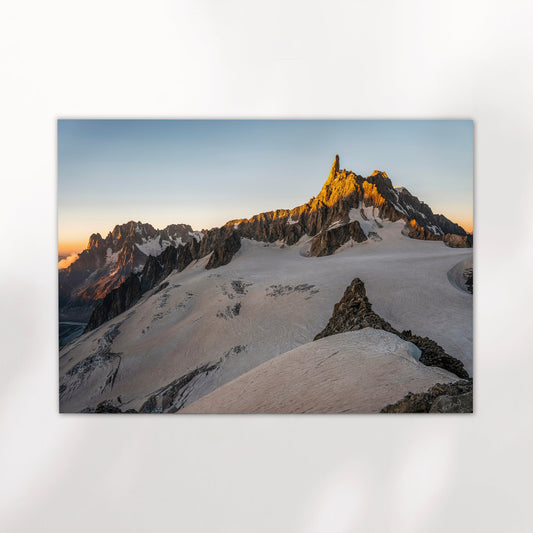 Golden hour photography print of Dent du Géant glowing in soft morning light above snowy alpine terrain.