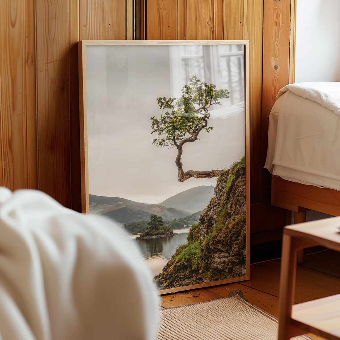 Fine art tree print leaning against a wood-panelled bedroom wall
